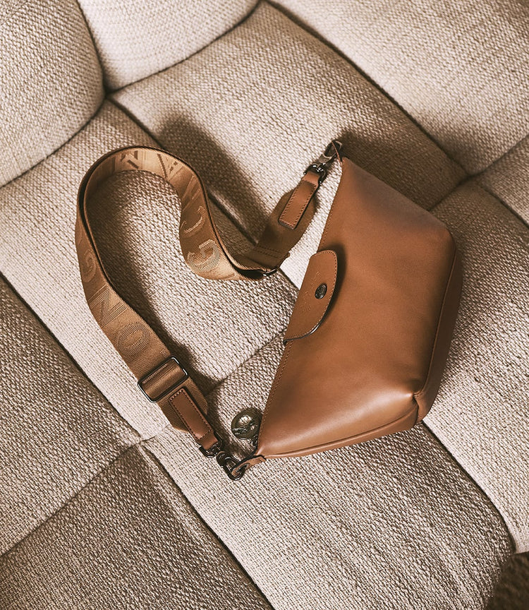 Longchamp leather shoulder bag resting on a woven cushion